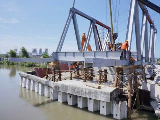 Para pekerja terkihat sedang menyelesaikan pengerjaan Jembatan Titi Dua Sicanang