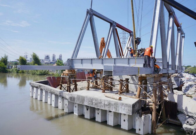 Para pekerja terkihat sedang menyelesaikan pengerjaan Jembatan Titi Dua Sicanang
