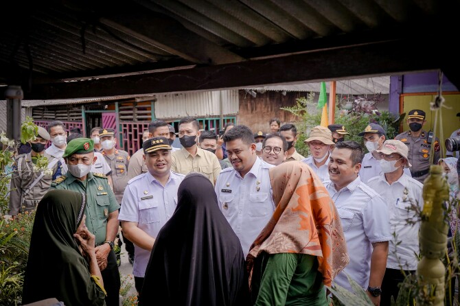 Walikota Medan, Bobby Nasution (tengah) saat berbincang dengan warga di sela sela peninjauan pengerjaan bedah rumah di Kelurahan Bagan Deli, Rabu (29/6/2022)