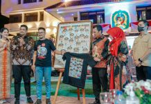 Walikota Pekanbaru bersama istri berfoto bersama Walikota Medan dan istri diantara lukisan poster wajah peserta Apeksi Komwil I Sumatera