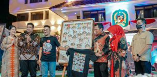 Walikota Pekanbaru bersama istri berfoto bersama Walikota Medan dan istri diantara lukisan poster wajah peserta Apeksi Komwil I Sumatera