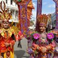 Dua orang muda mudi peserta karnaval budaya melintas di Jalan Ahmad Yani, Medan, Jumat (1/7/2022)