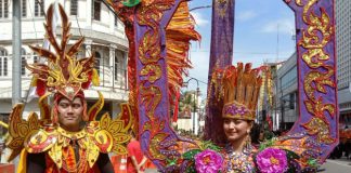 Dua orang muda mudi peserta karnaval budaya melintas di Jalan Ahmad Yani, Medan, Jumat (1/7/2022)