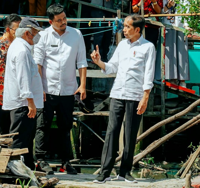 Presiden Joko Widodo berbincang dengan Walikota Medan, Bobby Nasution dan Menteri PUPR disela sela peninjauan pengerjaan rumah bedah di Kecamatan Belawan