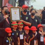 Walikota Medan, Bobby Nasution didampingi Ketua TP PKK Kota Medan menerima piagam Rekor MURI dan berfoto bersama dengan para siswa TK Kota Medan