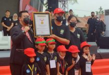 Walikota Medan, Bobby Nasution didampingi Ketua TP PKK Kota Medan menerima piagam Rekor MURI dan berfoto bersama dengan para siswa TK Kota Medan