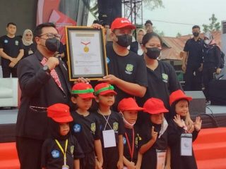 Walikota Medan, Bobby Nasution didampingi Ketua TP PKK Kota Medan menerima piagam Rekor MURI dan berfoto bersama dengan para siswa TK Kota Medan