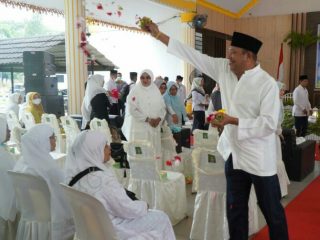 Plt Bupati Langkat saat menepungtawari jamaah haji yang baru tiba di tanah air