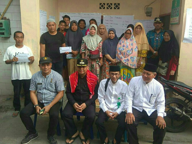 Ketua Baznas Kota Medan, Muhammad Nursyam berfoto bersama dengan Camat Medan Belawan, Sekcam Medan Belawan, dan para korban kebakaran di Jalan Cilacap Barat