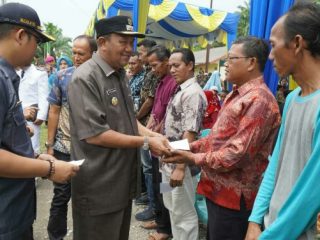 Plt Bupati Langkat, Syah Afandin saat menyerahkan bantuan sosial