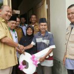Plt Bupati Langkat, Syah Afandin menyerahkan kunci rumah warga kurang mampu yang telah selesai dibedah, Selasa (20/9/2022)