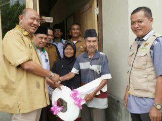 Plt Bupati Langkat, Syah Afandin menyerahkan kunci rumah warga kurang mampu yang telah selesai dibedah, Selasa (20/9/2022)