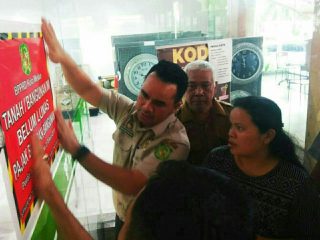 Personel Badan Pengelolaan Pajak dan Retribusi Daerah (BPPRD) Kota Medan menempelkan stiker dan memasang spanduk pemberitahuan menunggak Pajak Bumi dan Bangunan (PBB) di pintu masuk dan halaman Gedung Yuki Simpang Raya, Jalan SM Raja Medan, Selasa (27/9/2022).