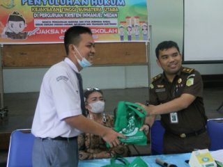 Kasipenkum Kejatisu Yos A Tarigan menyerahkan cinderamata pada pelajar Yayasan Immanuel Medan dalam kegiatan JMS.