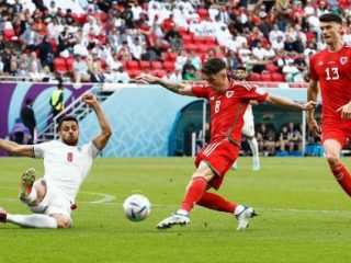 Pemain Iran berusaha menutup pergerakan pemain Wales. Iran menang 2-0
