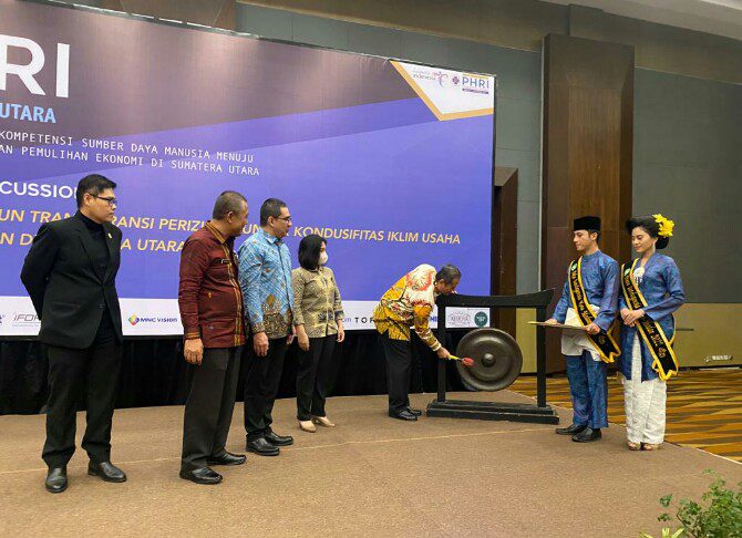Staf Ahli Gubsu Agus Tripriyono didampingi Ketua PHRI BPD Sumut Denny S Wardhana, memukul gong tanda dimulainya Rakerda PHRI kedua di Hotel Santika, Kamis (1/12/2022).