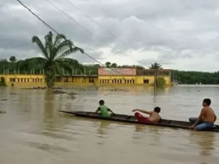 Sejumlah anak bermain perahu di tengah banjir di dekat kampus STAI Aceh Tamiang, Minggu (22/1/2023). Sejumlah wilayah di pesisir timur Provinsi Aceh mengalami banjir yang mengakibatkan ribuan orang mengungsi.(kaldera/ist)