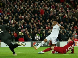 Pemain Real Madrid, Eder Militao berusaha dihalangi pemain Liverpool ketika melepaskan tendangan saat laga babak 16 besar Liga Champions 2022/2023 di Stadion Anfield, Rabu (22/2/2023). Dalam laga itu, Real Madrid Menang 5-2. Foto:Reuters