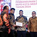 Walikota Medan, Bobby Afif Nasution menyerahkan penghargaan kepada Sekretaris DPRD Medan, Ali Sipahutar dalam lomba inovasi pelayanan publik Kota Medan, Kamis (16/3/2023). Foto:Dinas Kominfo Kota Medan