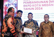 Walikota Medan, Bobby Afif Nasution menyerahkan penghargaan kepada Sekretaris DPRD Medan, Ali Sipahutar dalam lomba inovasi pelayanan publik Kota Medan, Kamis (16/3/2023). Foto:Dinas Kominfo Kota Medan