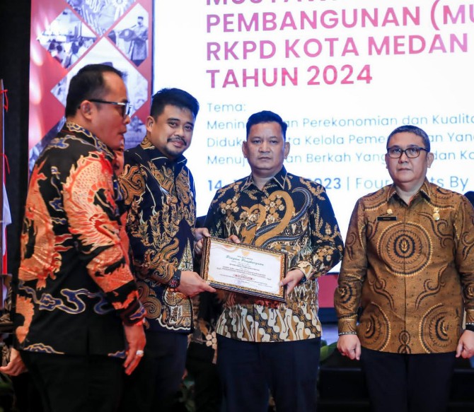 Walikota Medan, Bobby Afif Nasution menyerahkan penghargaan kepada Sekretaris DPRD Medan, Ali Sipahutar dalam lomba inovasi pelayanan publik Kota Medan, Kamis (16/3/2023). Foto:Dinas Kominfo Kota Medan