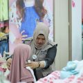 Srikandi GIS sedang mengarahkan anak yatim yang berbelanja pakaian lebaran di salah satu pusat perbelanjaan