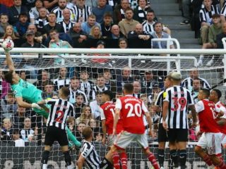 Penjaga gawang Newcastle berusaha menepis bola dari serangan pemain Arsenal saat kedua tim bertanding di Stadion St James Park, Minggu (7/5/2023). Dalam laga itu, Arsenal menang 2-0. Foto:Reuters