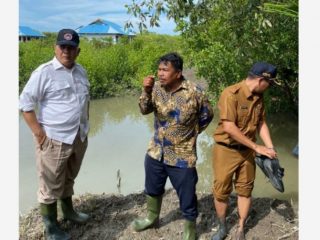 Kadisdik Sumut Asren Nasution (baju putih) didampingi Kacabdis V Abdul Kadir Simorangkir (kanan) berdiri dengan latarbelakang SMKN 1 Medan Deras. Lokasi sekolah ini akan dipindah ke SMAN 1 Medang Deras.