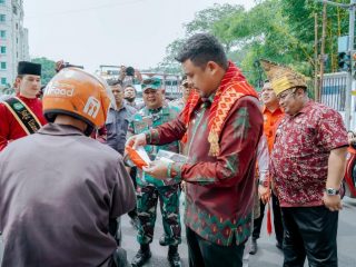 Walikota Medan, Bobby Nasution memberikan bendera merah putih kepada pengendara yang melintas di Jalan Kapten Maulana Lubis, Jumat (7/7/2023)