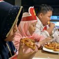 Sejumlah anak yatim sedang menikmati pizza
