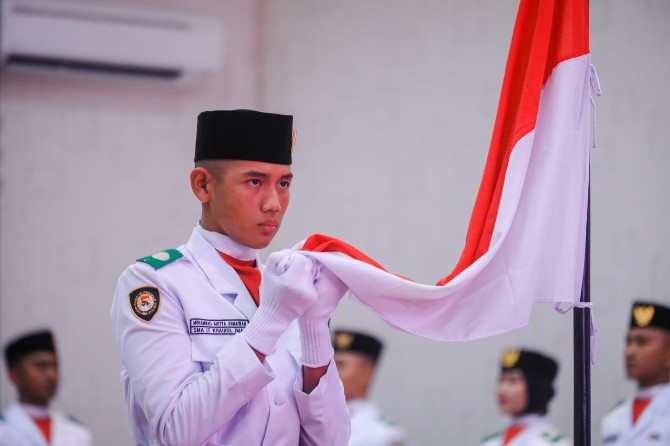 Salah satu Paskibraka Kota Medan tahun 2023 mencium bendera merah putih usai dikukuhkan Walikota Medan, Bobby Nasution