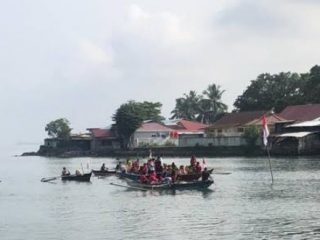 Puluhan Nelayan dan Masyarakat Batang Arau Melaksanakan Upacara Pengibaran Bendera Ditengah Muara Batang Arau