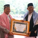 Plt Bupati Langkat, Syah Afandin saat menerima penghargaan kepala daerah peduli pondok pesantren dari Kepala Wilayah Kementrian Agama Sumut