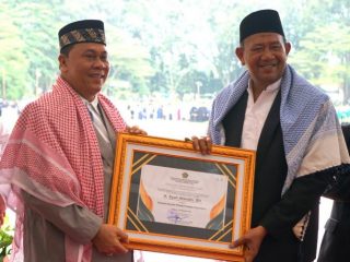 Plt Bupati Langkat, Syah Afandin saat menerima penghargaan kepala daerah peduli pondok pesantren dari Kepala Wilayah Kementrian Agama Sumut