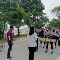 DRUM BAND: Seorang pesepeda melintas di hadapan formasi tim Drum Band Sumut yang tengah menjalani latihan di kawasan Jalan Arteri Kualanamu, Sabtu (3/8/2024). Drum band Sumut semakin matang dalam taktik dan fisik untuk meraih 7 medali emas di PON 2024.(HO/kaldera)