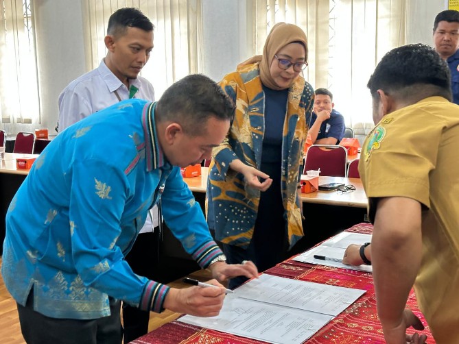 Anggi Maisarah (berhijab) saat penandatanganan kerjasama dengan GM BP-TC UGGp, Azizul Kholis.