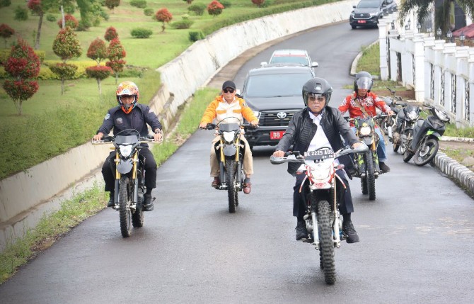 Bupati Tapsel meninjau lokasi irigasi rusak dengan bersepeda motor.