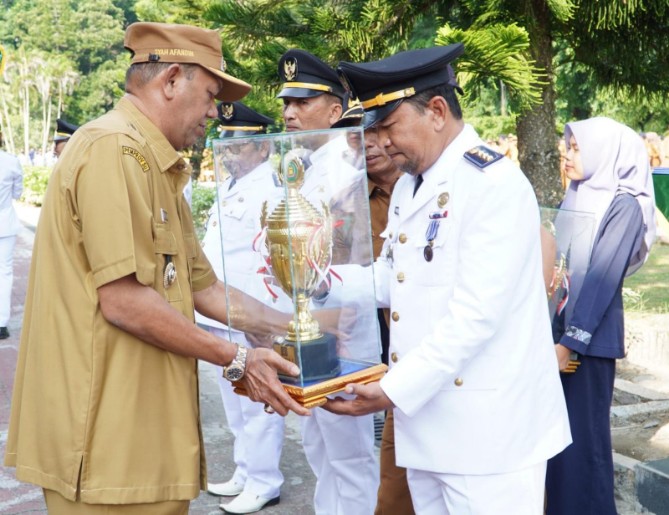 Bupati Langkat Syah Afandin, menyerahkan penghargaan kepada kecamatan dan kelurahan terbaik tingkat Kabupaten Langkat tahun 2025. Penyerahan berlangsung usai apel gabungan ASN di halaman Kantor Bupati Langkat, Stabat, Senin (22/9/2025).
