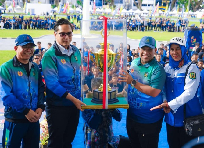 Wali Kota Medan Rico Waas didampingi Wakil Wali Kota Medan, Zakiyuddin menyerahkan Piala Juara Umum kepada Camat Medan Selayang pada penutupan Porkot Medan di Lapangan Merdeka, Jumat (17/10/2025). Foto: Dinas Kominfo Medan