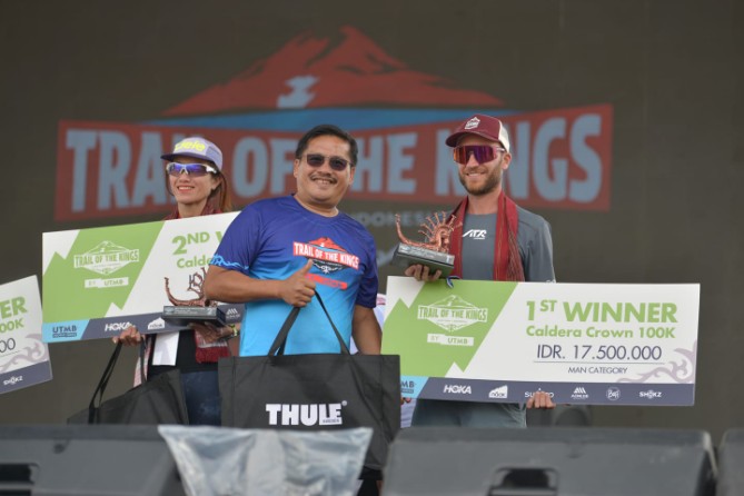 Sekretaris Daerah Provinsi Sumatera Utara (Sumut) Togap Simangunsong menyerahkan piala dan hadiah kepada para pemenang lari lintas alam Trail of The Kings Lake Toba by UTMB di panggung utama Waterfront Pangururan Kabupaten Samosir, Minggu (19/10/2025). Foto : Diskominfo Sumut