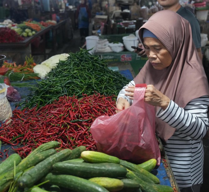 Salah seorang pedagang cabai di Pasar Petisah Medan sedang melayani pembeli. Harga cabai merah kini turun menjadi Rp35.000/ kilo. Foto: Reza Sahab/kaldera.id