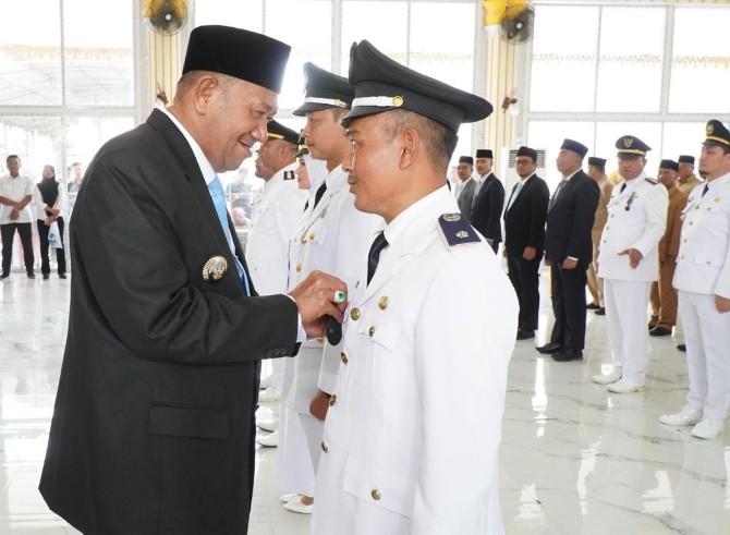 Bupati Langkat Syah Afandin menyematkan tanda pangkat kepada lurah yang baru dilantik. Foto: Dokumen Dinas Kominfo Langkat