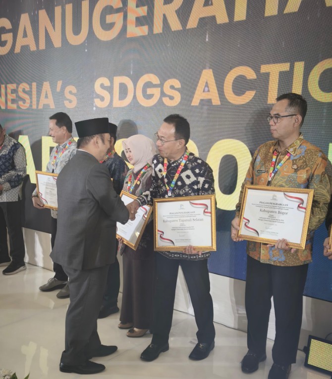 Menteri Perencanaan Pembangunan Nasional/Kepala Badan Perencanaan Pembangunan Nasional Rachmat Pambudy (kiri) menyerahkan penghargaan Indonesi’s SDGs Action Awards 2025 Bappenas setelah melalui seleksi pada integrated sustainabily Indonesia movement (I-SIM) 2025 kepada Bupati Tapsel Gus Irawan Pasaribu di Gedung Utama Kantor Kementerian PPN/Bappenas Rabu (19/11/2025).