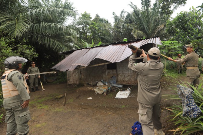 Personel Satpol PP membongkar bangunan liar yang berdiri di atas lahan HPL Pemko Medan di Jalan Flamboyan. Foto: IST