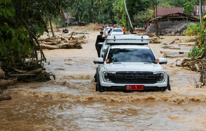 Mobil Dinas Gubernur Sumut Bobby Nasution menerjang banjir di kawasan Tukka Tapanuli Tengah. Foto : IST