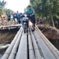 Seorang pengendara melintas di jembatan sementara akibat jalan putus di Desa Tanjung Putus, Kecamatan Padang Tualang, Kabupaten Langkat, Jumat (5/12/2025). Foto; Reza Sahab/kaldera.id