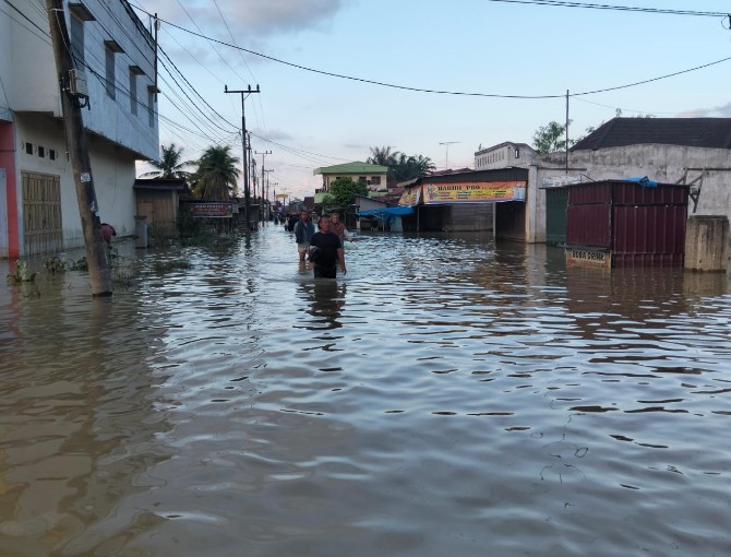 Warga Desa Pekubuan, Kecamatan Tanjung Pura terlihat berjalan di tengah banjir untuk menyelamatkan diri. Banjir di Tanjung Pura disebabkan tanggul sungai yang jebol. Foto: Reza Sahab/kaldera.id