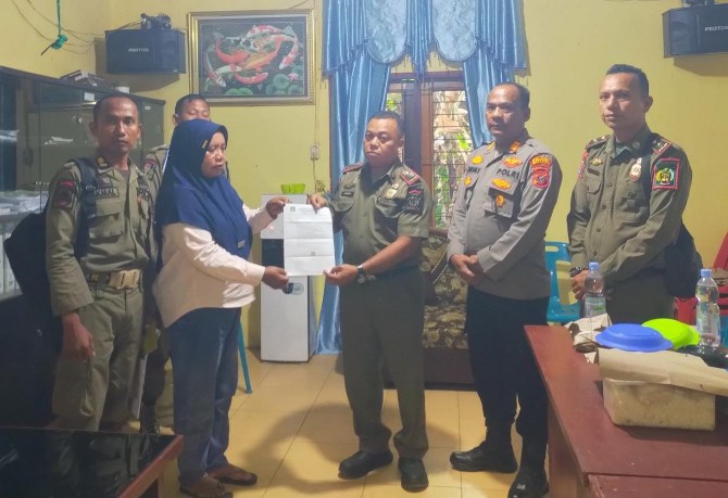 Personel Satpol PP menyerahkan SP 2 untuk manajemen Blue Night yang diwakilkan perangkat desa. Foto ; IST