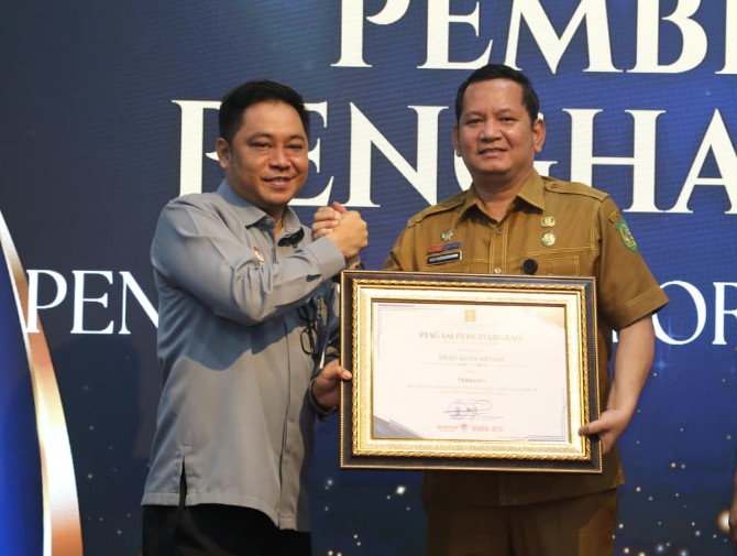 Sekretaris DPRD Medan Ali Sipahutar menerima penghargaan E- Report JDIHN dari Pelaksana Harian (Plh) Kepala Kantor Wilayah Kementerian Hukum Sumatera Utara, Ferry Ferdiansyah. Foto; IST