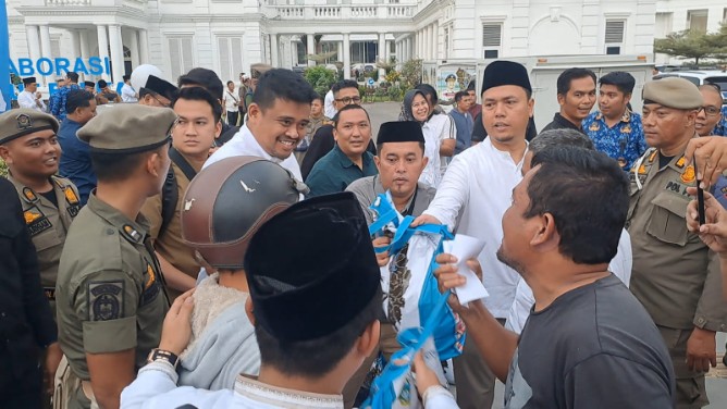 Gubernur Sumatera Utara Bobby Nasution membagikan tunjangan hari raya (THR) kepada masyarakat di Medan, Selasa (17/3/2026).